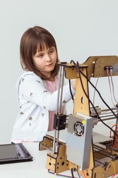 Little child architect using 3D Printer. Schoolgirl, technologies and study.