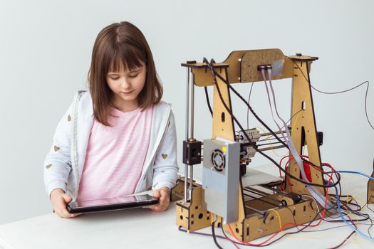 Cute girl with 3d printed shutter shades is watching her 3d printer as it prints her 3d model