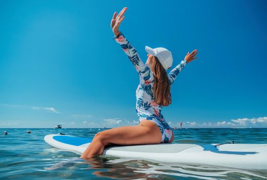 SUP Stand up paddle board. Young woman sailing on beautiful calm sea with crystal clear water. The concept of an summer holidays vacation travel, relax, active and healthy life in harmony with nature