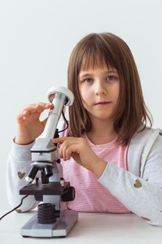 Child girl in science class using digital microscope. Technologies, children and learning.