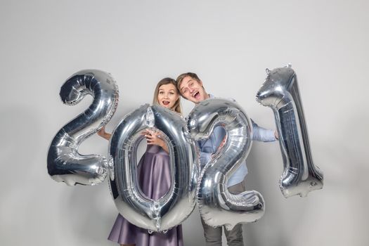 Party, people and new year holidays concept - woman and man celebrating new years eve 2021.