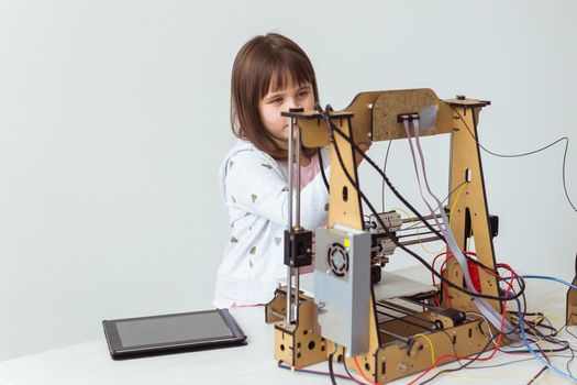 Little child architect using 3D Printer. Schoolgirl, technologies and study.