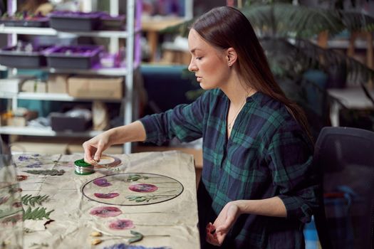 Confident female florist is working with dryed flowers in cozy flower shop