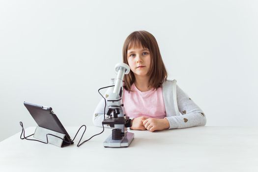 Child girl in science class using digital microscope. Technologies, children and learning.