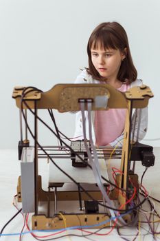 Little child architect using 3D Printer. Schoolgirl, technologies and study.