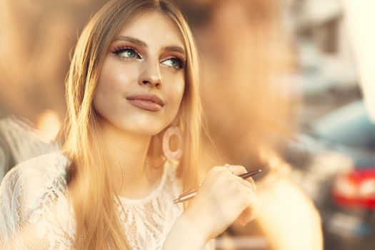 Attractive young woman daydreaming and looking through the window. Close up.