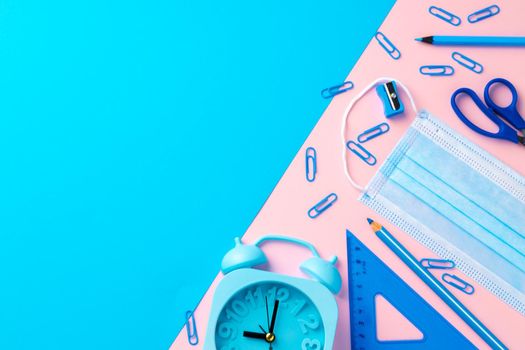 School stationery items and medical face mask, top view