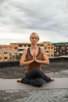 Woman enjoys practicing yoga on the roof.