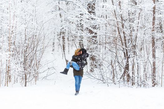 Happy loving couple having fun outdoors in snow park. Winter vacation.