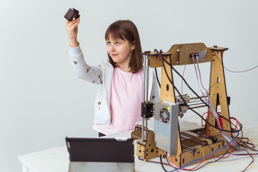 Child student makes the item on the 3D printer. School, technologies and science.
