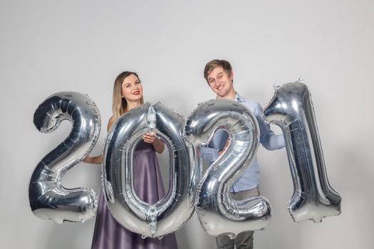 Party, people and new year holidays concept - woman and man celebrating new years eve 2021.