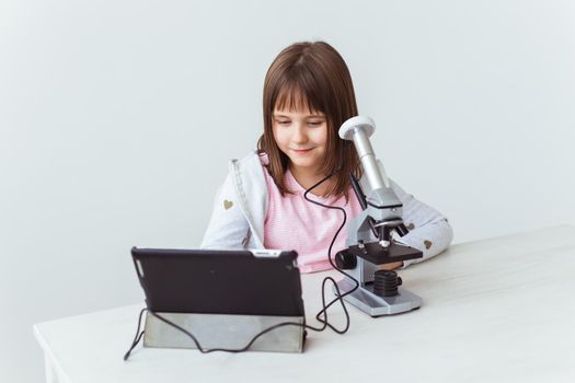 Child girl in science class using digital microscope. Technologies, children and learning.