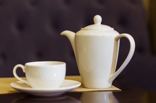 Tea cup and tea pot on table. Breakfast and Five O'Clock Tea.