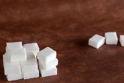 Sugar cubes with spoon top view on brown natural colored background texture with copy space, Sugar,sweet,health,food concept food