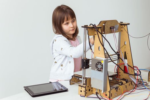 Cute girl with 3d printed shutter shades is watching her 3d printer as it prints her 3d model