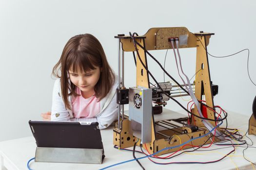 Cute girl with 3d printed shutter shades is watching her 3d printer as it prints her 3d model