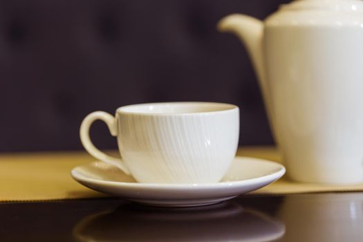 Tea cup and tea pot on table. Breakfast and Five O'Clock Tea.