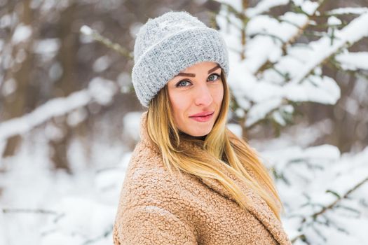 Attractive young woman in winter time outdoor. Snow, holidays and season.