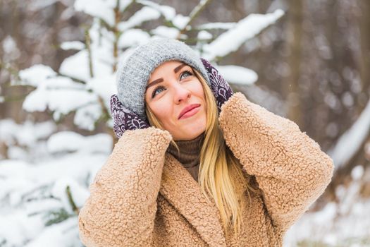 Beautiful winter portrait of young woman in the winter snowy scenery.