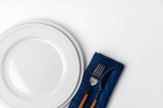 Fork, knife and plate on towel. Isolated on white background. Close up.