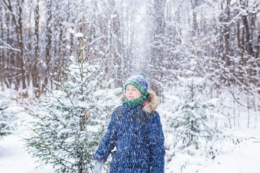Happy boy throwing snow. Child, season and winter concept