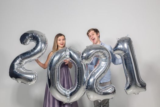 Party, people and new year holidays concept - woman and man celebrating new years eve 2021.