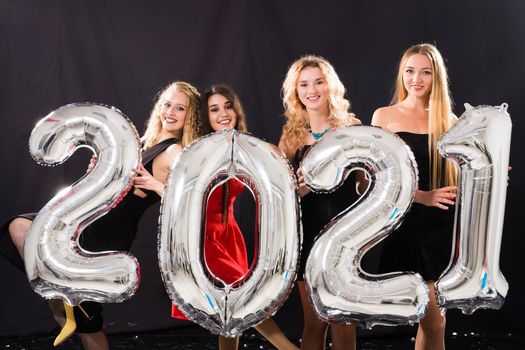 Party and new year holidays concept - cheerful young women celebrating new years eve 2021