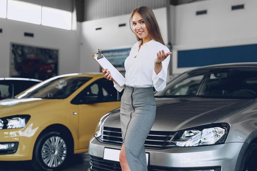 Happy beautiful young woman car dealer in showroom close up