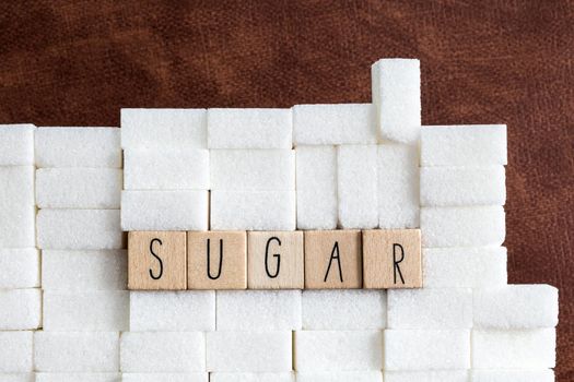 Sugar cubes wall with the text Sugar on brown natural background texture, Health,diabetes,medical,sugar,sweet.junk food concept copy space