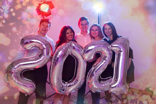 Party and new year holidays concept - women and men celebrating new years eve 2021