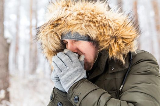 Young couple in love drink a hot drink from a thermos and enjoy winter nature