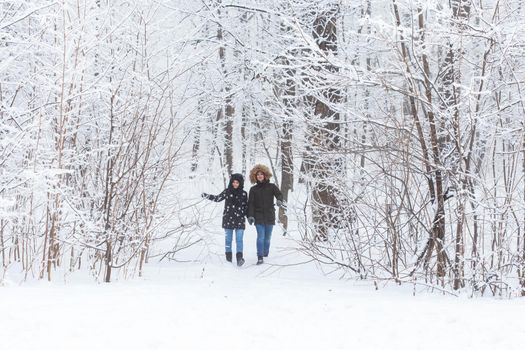 Happy loving couple having fun outdoors in snow park. Winter vacation.