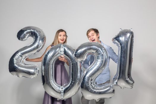 Party, people and new year holidays concept - woman and man celebrating new years eve 2021.