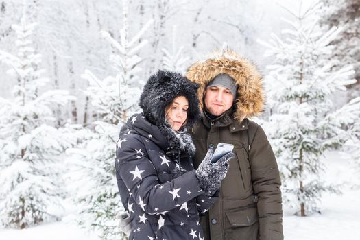 Season and relationship concept - Funny couple taking selfie in the winter time.