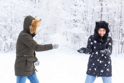 Fun, season and leisure concept - love couple plays winter wood on snow