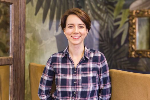 Portrait of confident woman smiling in cafe.