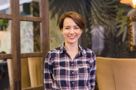 Portrait of confident woman smiling in cafe.