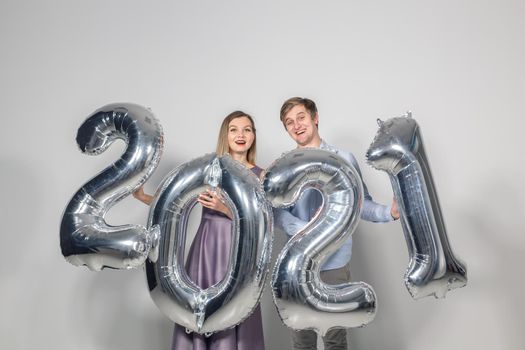 Party, people and new year holidays concept - woman and man celebrating new years eve 2021.