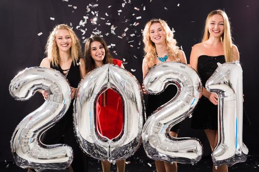 Party and new year holidays concept - cheerful young women celebrating new years eve 2021