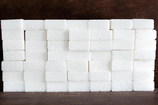 White sugar cubes composition of Brick wall, pile of sugar, unhealthy food, ingredient, candy and sweets closeup