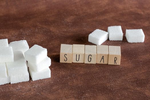 Sugar cubes with spoon top view on brown natural colored background texture with copy space, Sugar,sweet,health,food concept food