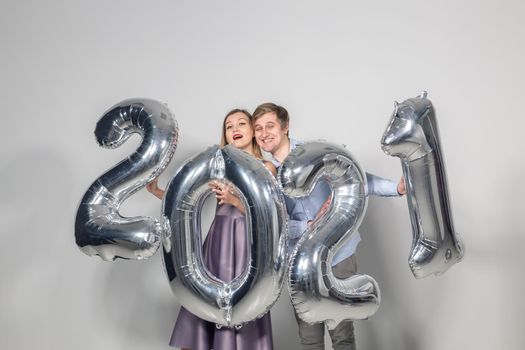 Party, people and new year holidays concept - woman and man celebrating new years eve 2021.