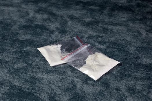 Transparent plastic bags with white powder, cocaine,speed or other drugs on gray background with copy space, dealing,drug,junky,addiction concept illegal