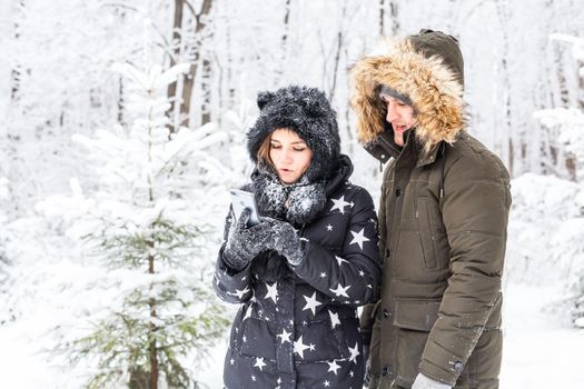 Season and relationship concept - Funny couple taking selfie in the winter time.