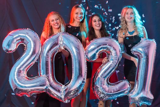Party and new year holidays concept - cheerful young women celebrating new years eve 2021