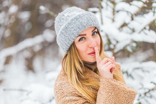 Beautiful winter portrait of young woman in the winter snowy scenery.