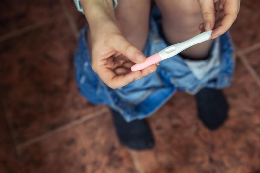 Young woman checking results of a pregnancy test in bathroom close-up, new life,family,mother,baby concept modern design