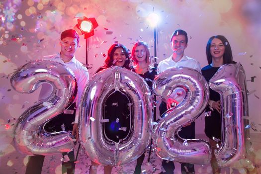 Party and new year holidays concept - women and men celebrating new years eve 2021