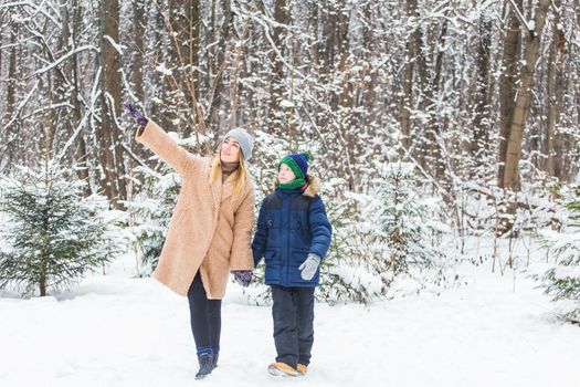 Portrait of happy mother with child son in winter outdoors. Single parent.