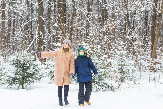 Portrait of happy mother with child son in winter outdoors. Single parent.